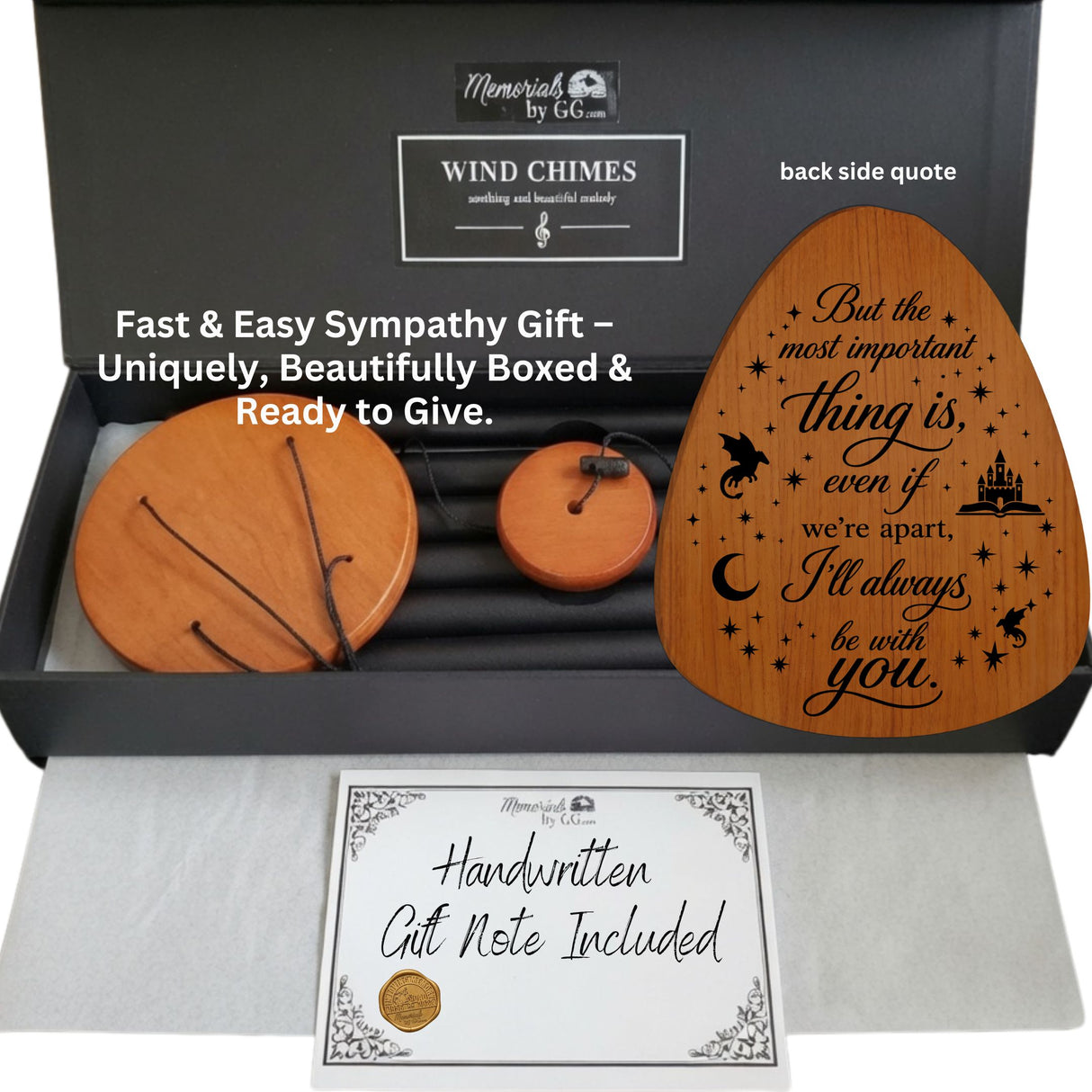 A memorial wind chime gift set shown in an open black presentation box with a handwritten gift note included. The set includes a large round wooden wind chime, a smaller round wooden wind chime, a single wooden chime with a string, and a black metal wind chime.